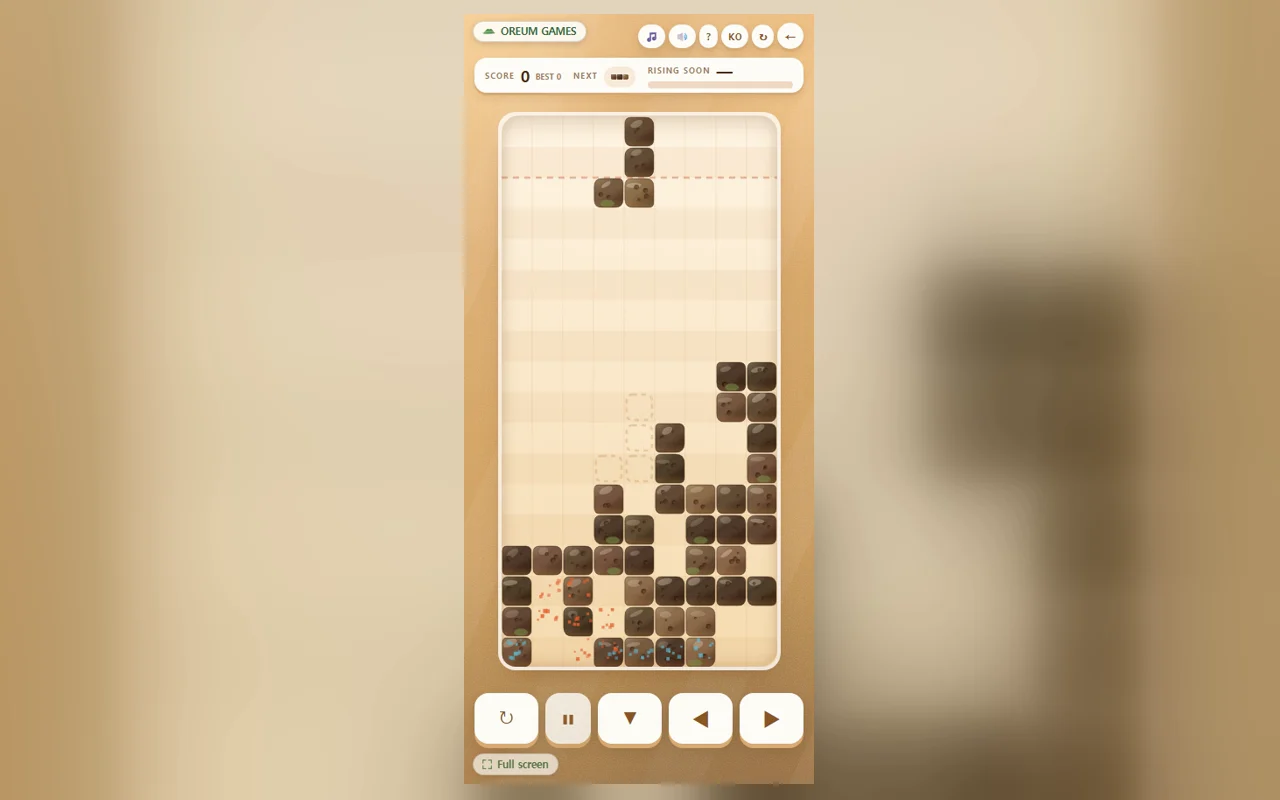 Black blocks stacked on a sandy board, one completed row glowing with a gold outline